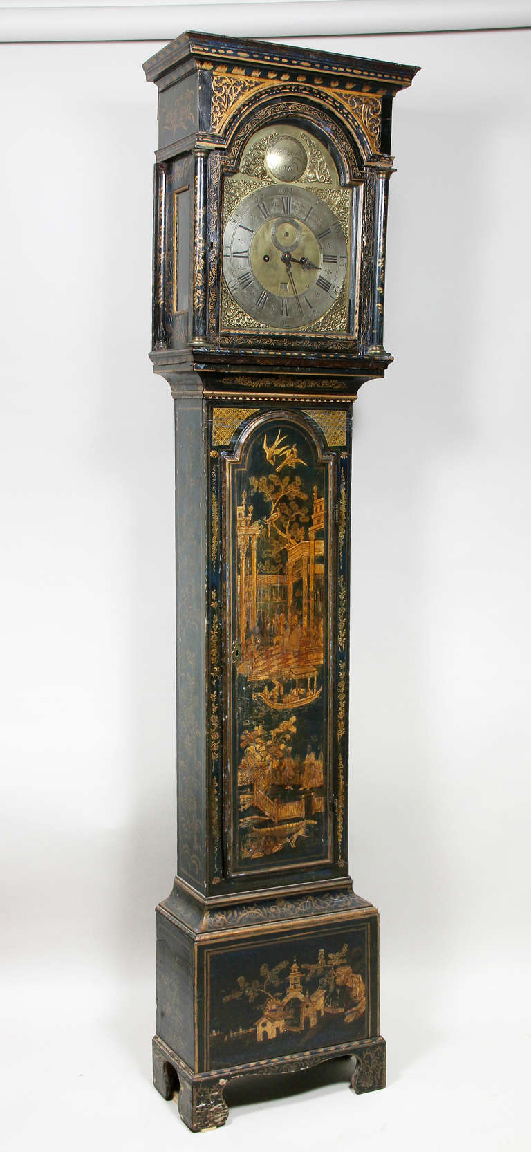 Flat bonnet with blind fret spandrels over an arched glazed door enclosing brass works by Thomas York , London. The waisted case section with door , plinth base and bracket feet.