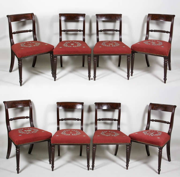 Each with a reeded and string inlaid tablet crest rail over a turned stretcher , circular tapered reeded legs. Needlepoint seats. Comprising a pair of arms and eight sides.