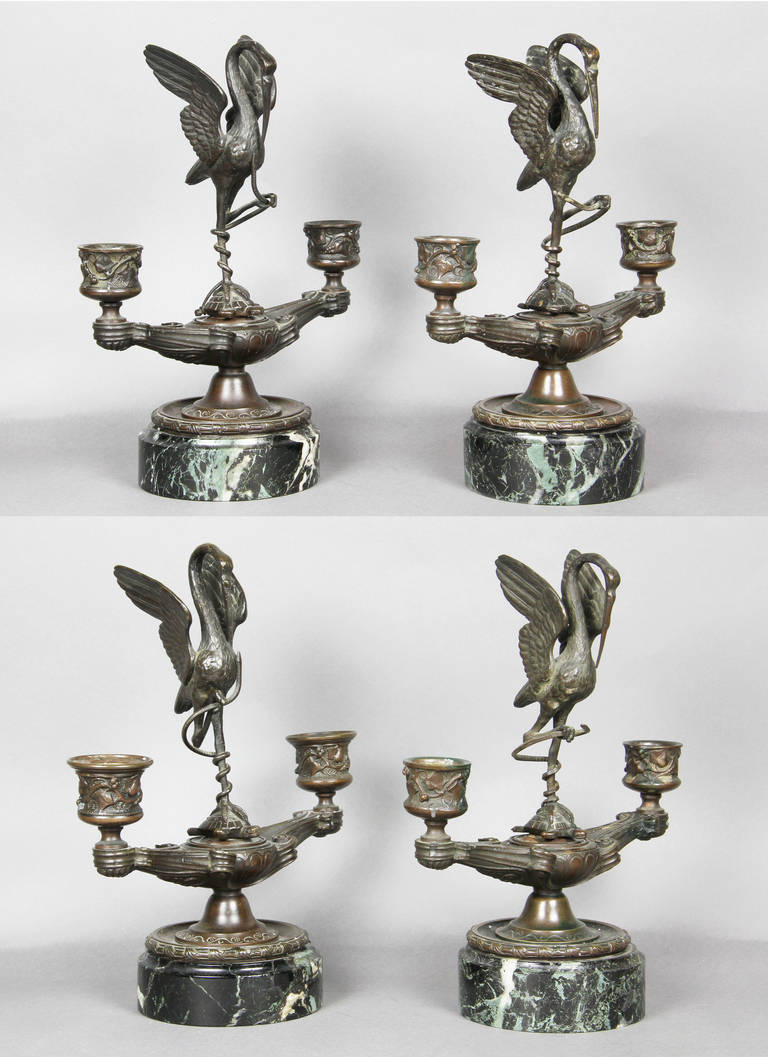 Two candleholder with stork standing on turtles back raised on a circular antico verde base.