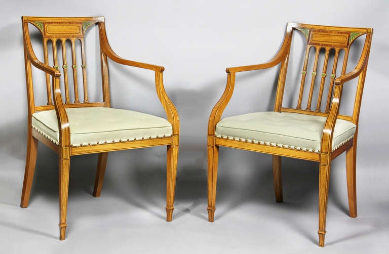 Each with tablet crest rail with rosewood banding and hand painted lunettes , above five spindles , light celadon leather seats ,raised on square tapered legs. Provenance : William Hodgins Interiors and Malletts, London