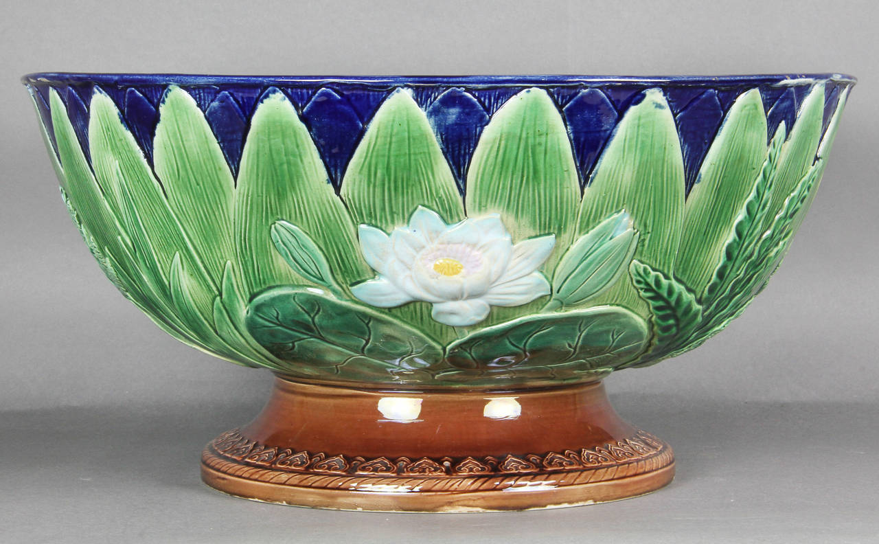 Circular with robins egg blue interior and with exterior decoration featuring lily pads and pointed leaves , brown glazed foot.