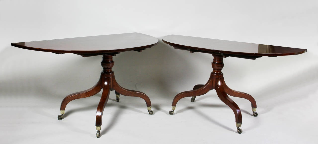 Beautifully figured top with two original leaves, the center section a table with four molded straight legs with optional swing out legs to support leaves, leaves also are supported by pull-out bars and clips, raised on urn shaped turned legs each