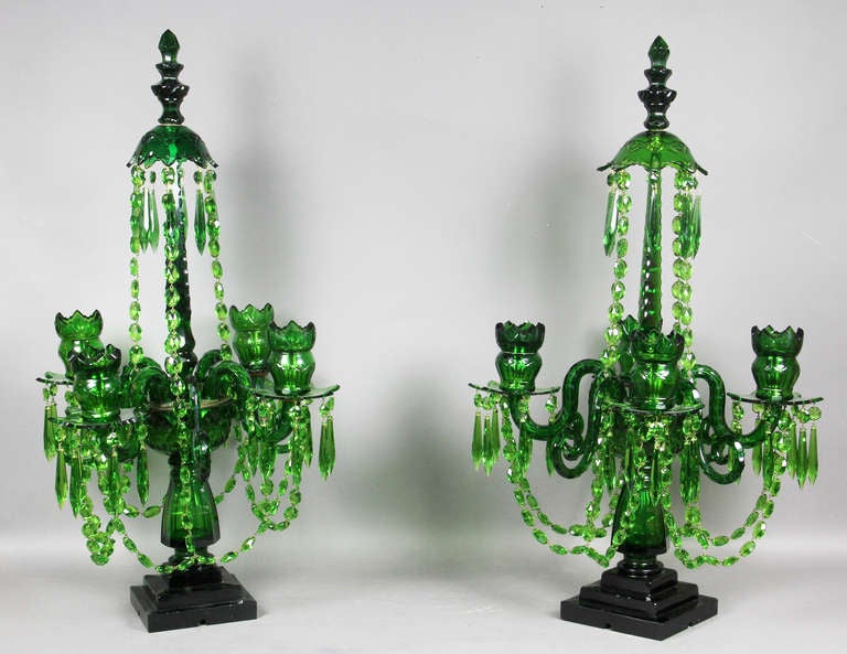 Each with a cut glass detachable finial over a canopy supported on a spire , the base with four candle arms with cut glass swags ,  on a shaped support with square stepped base.