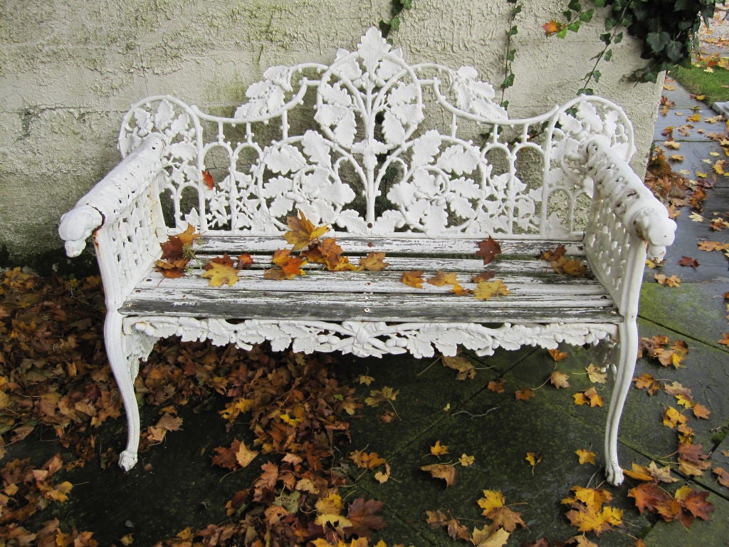 White cast iron bench with wooden seat.  Arms have cast dog heads terminals.<br />
<br />
Provenance: From the Estate of Richard Sears in Prides Crossing, MA.