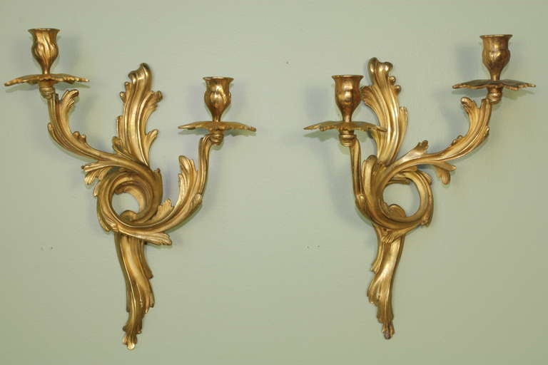 Four pairs of elegant French gilt-bronze Louis XV style sconces, showing fine flowing rococo elements and design (Circa 1880).  The sconces retain their lovely original gilding.  These are true pairs, i.e. mirror images of each other, and not just