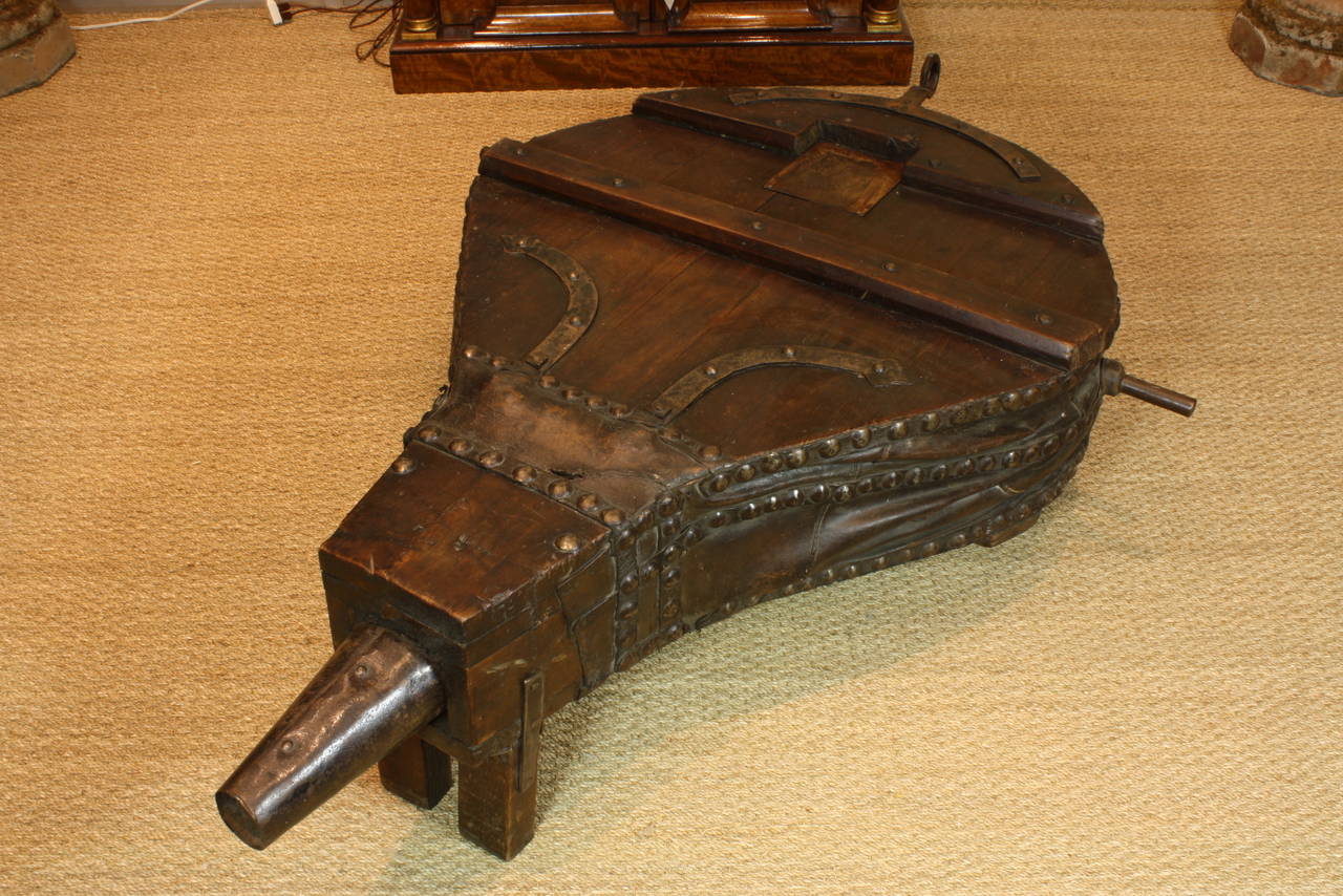 French 19th century blacksmith's bellows retrofitted as a coffee table. The table features wonderful patina, hand-wrought iron hardware, leather and studs.