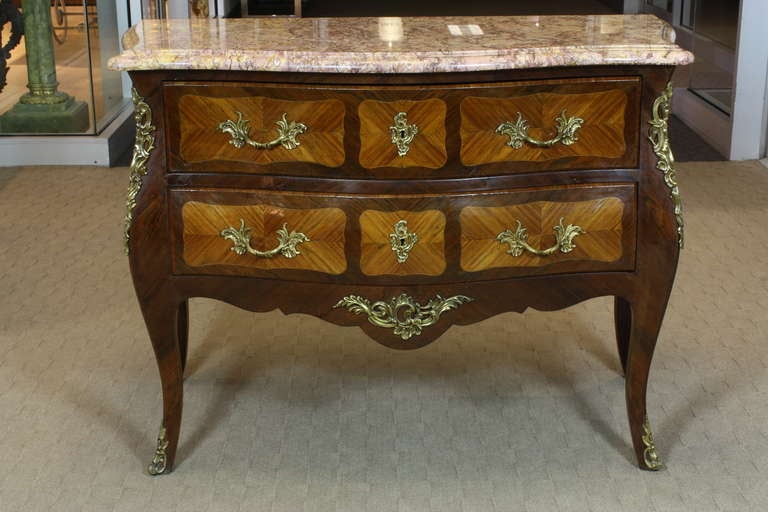 French marquetry commode with nice marble top, two drawers, foliate bronze hardware (Louis XV style, circa 1880). Commode has working locks with key. Marquetry of bois de rose (or tulipwood) and bois Violette (or kingwood).