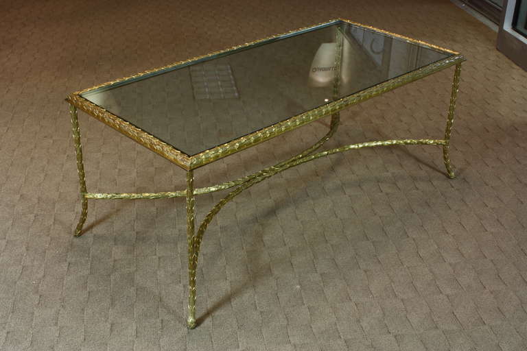 An elegant, high-quality French gilt-bronze and glass top coffee table with finely cast and chased leaf frame by Maison Baguès (Circa 1940).  The top is new 1/2
