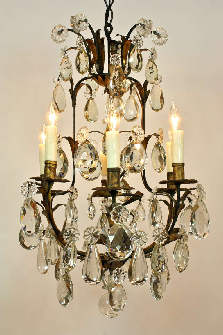 A very high-quality French iron and gilt-tole cage chandelier with six lights, embellished with beautiful, very thick and finely-cut and smooth crystals (early 20th century).  The frame is decorated with gilt-tole foliate details.