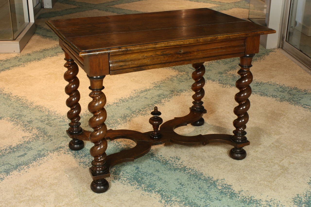 A nice Baroque period walnut desk or center table with spiral-turned legs, ball feet, and finial stretcher, having a single drawer (no lock) (Louis XIII period, Circa 1700).