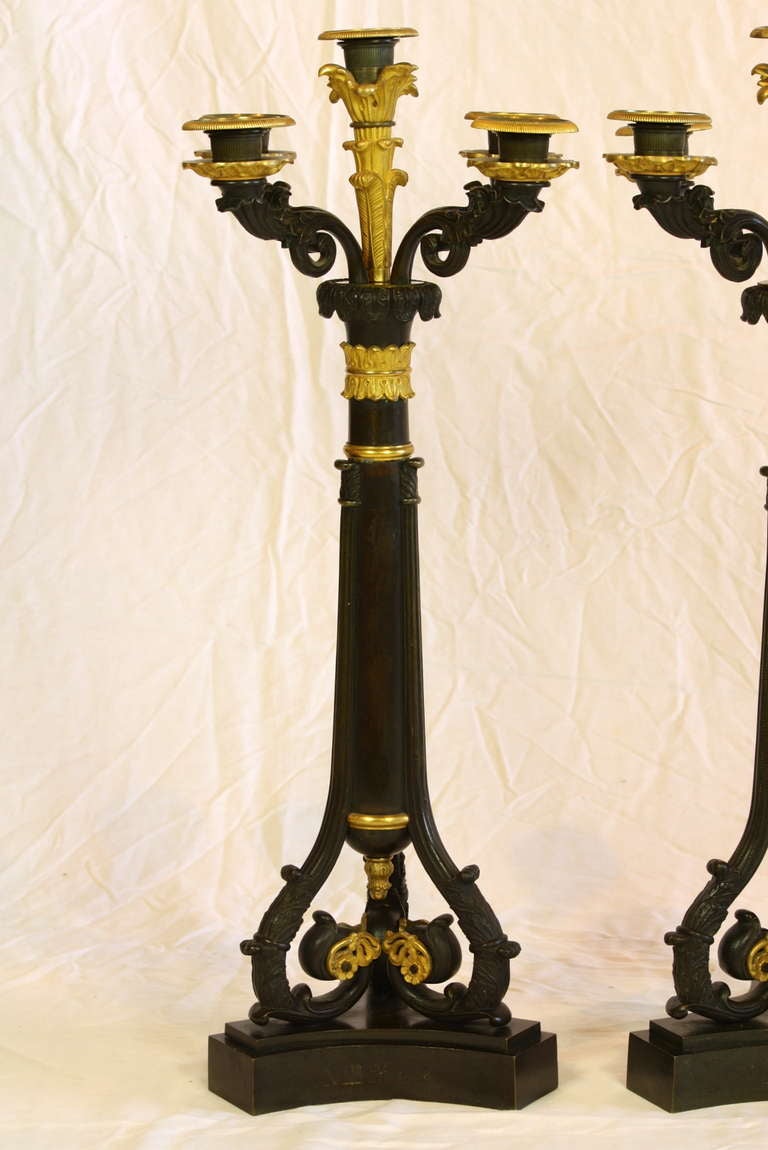 Pair of Charles X ormolu and patinated bronze candelabra with five arms and separate bobesches. The base of each candelabra is inscribed with an 