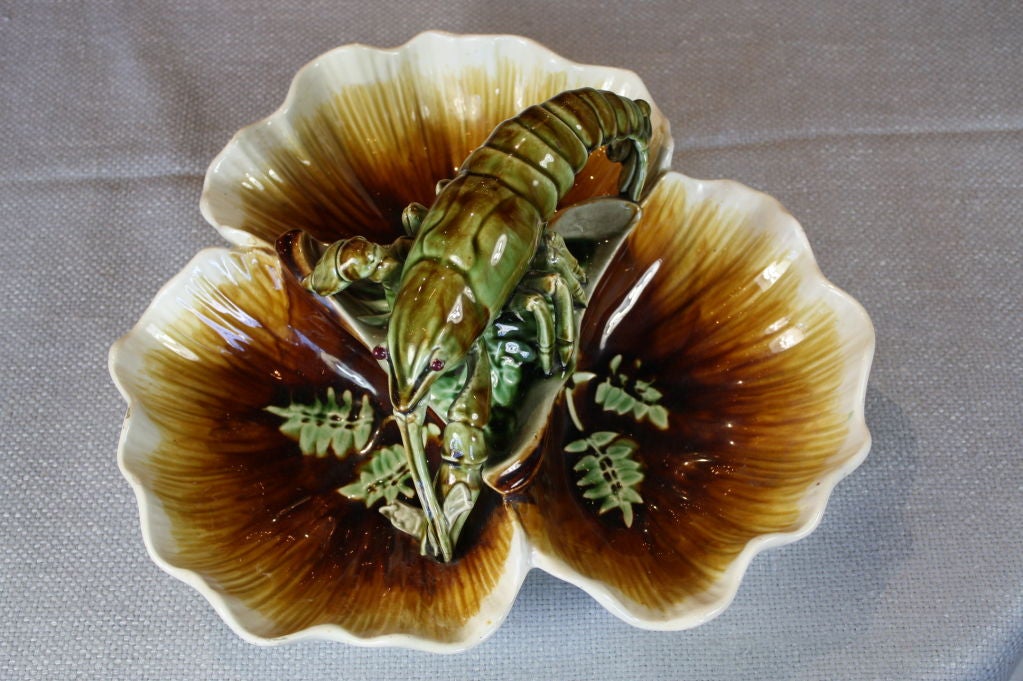 French barbotine scallop shell form centerpiece depicting a lobster holding a small fish, seaweed detailing, wonderful green, brown and gold coloration. Marked underneath, 