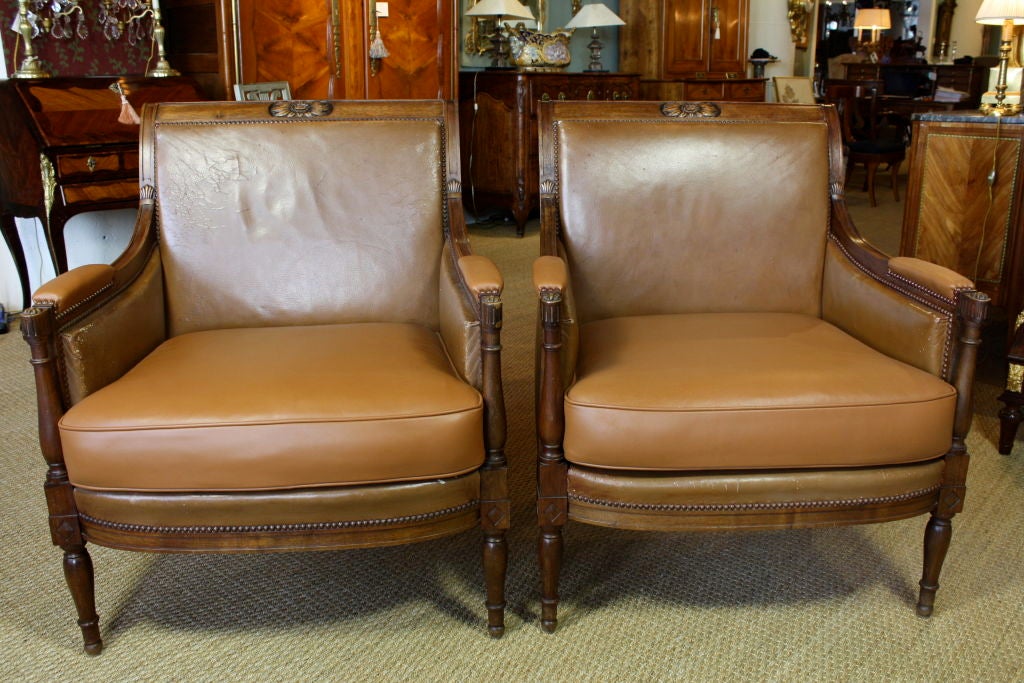 Nice pair of French mahogany arm chairs in the Directoire style with leather upholstery.  Leather on the seats and arms has been replaced.