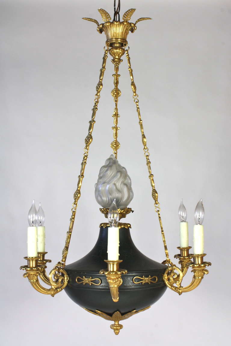 Lampadario in stile Impero francese con bracci in bronzo dorato, montature neoclassiche, catena e baldacchino ornati. Il corpo centrale è in legno dipinto di verde scuro, sormontato da un terminale a fiamma in vetro smerigliato. Cablato per gli