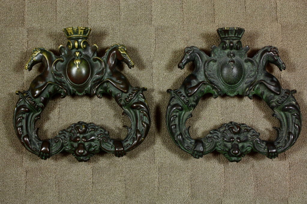 Pair of very heavy, beautifully-cast bronze door pulls or knockers from an 18th century Chateau near Fontainbleau, France.  Door pulls feature a pair of horses on either side of a French family crown, terminating in a lion's head and paws (Louis XVI