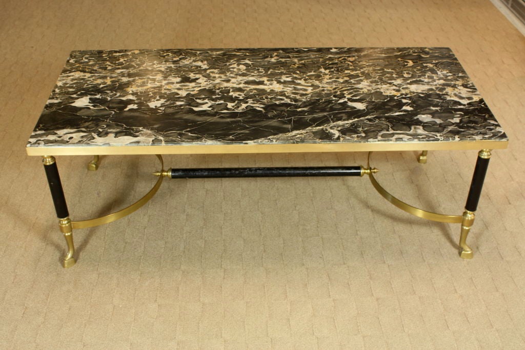French bronze and brass coffee table by Maison Charles, with nicely-veined black marble top. The feet are stylized horse hooves. and the tubular sections are patinated.