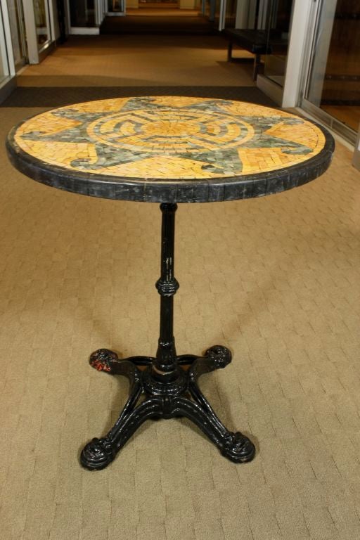 French bistro table with marble mosaic top in vitruvian scroll and Greek key designs. Table base is black painted cast iron.
