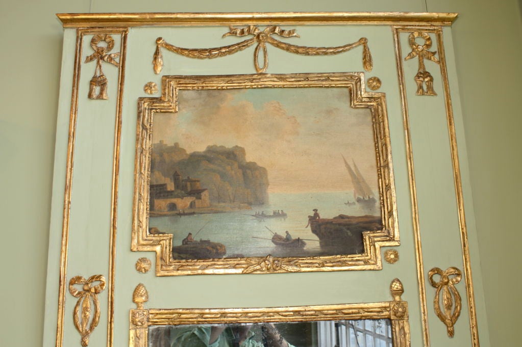 French painted and parcel-gilt trumeau mirror with painting of a fishing harbor (probably Marseilles).  Nice gilded urn and swag detailing and other neoclassical ornamentation.  Original mercury glass mirror.  Background milk paint has been restored.