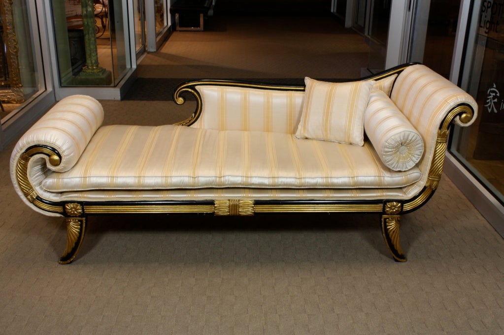 Elegant French ebonized and parcel gilt recamier or chaise, in the style of Maison Jansen, neoclassical form, with vintage silk striped fabric, separate seat cushion, roll cushion and small square pillow.