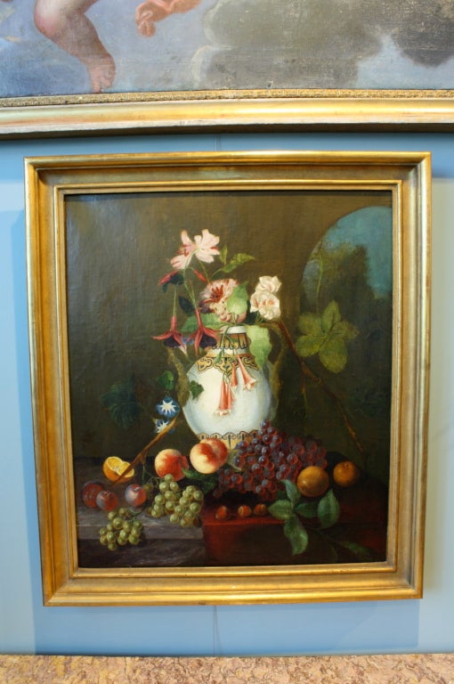 French school oil painting of a Moroccan vase with orchids, fuschia, morning glories, nectarines, grapes and chestnuts. The arch in the upper right corner adds an air of mystery to the exotic scene, reminicent of early Gauguin.