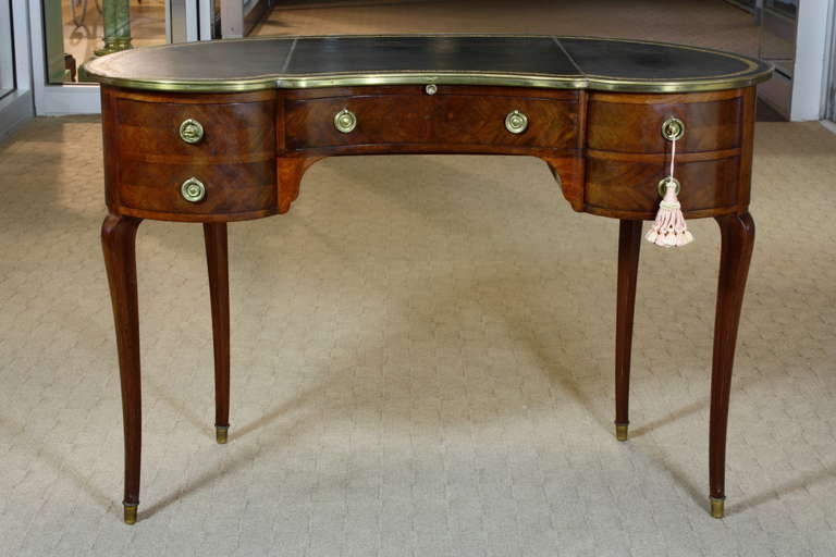 A very rare, beautifully-made French kidney form desk with cabriole legs, original tooled black leather top (Circa 1891).  The desk features a central drawer (having a brass key plate engraved 