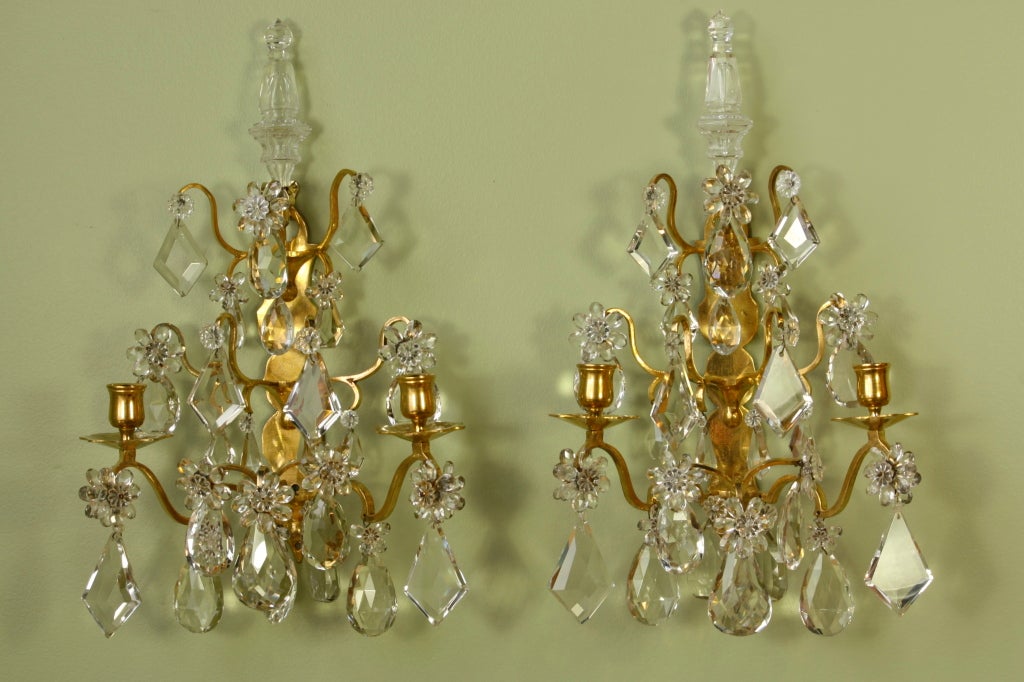 Pair of high-quality gilt-bronze and crystal sconces with nice, large crystals and many crystal flowers, and poignards on top.  The sconces retain their original fire gilding in glowing condition.  Each sconce has two arms and could be