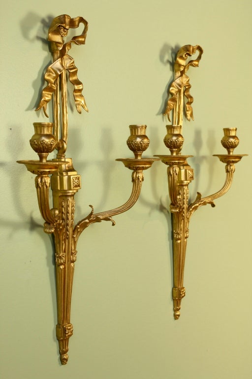 Elegant pair of French gilt bronze two-arm sconces with ribbon, acanthus leaves, berries, rosettes and other neoclassical ornamentation (Louis XVI style, late 19th century). Can be electrified upon request.