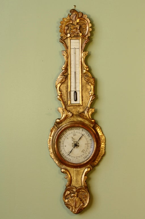 An elegant French gilded wood barometer with thermometer (period Louis XV, Circa 1760).  Barometer has been fitted with a new mercury tube, and is in working condition.  The face is signed 