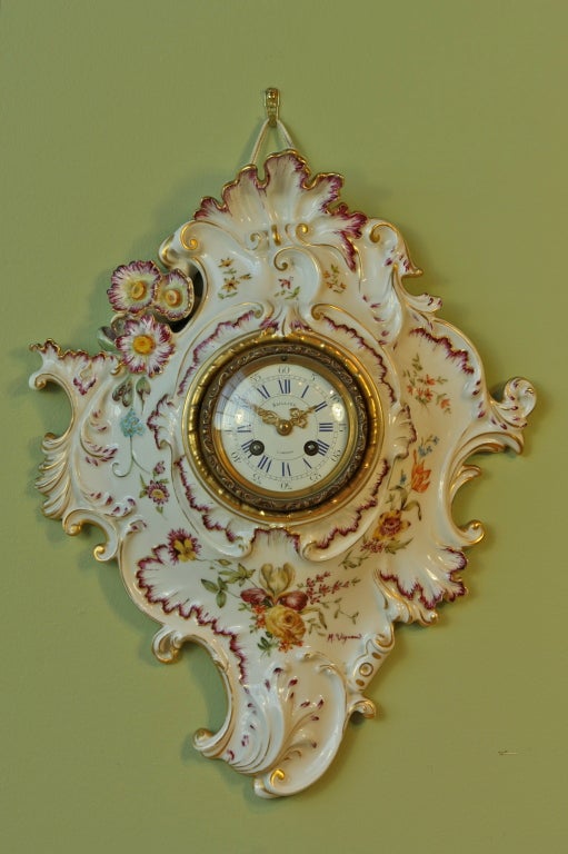 A charming French Limoges painted porcelain wall clock in the Louis XV style.  The porcelain dial is signed 