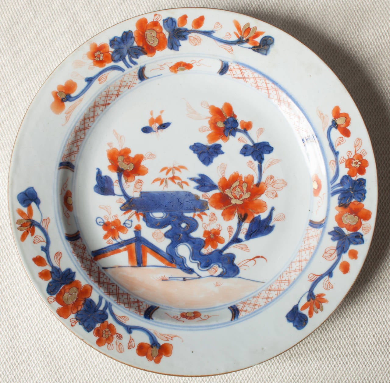 Chinese export porcelain plate in the Chinese Imari style of decoration. The plate is hand painted in an underglaze blue and overpainted in iron red. The diameter is 9