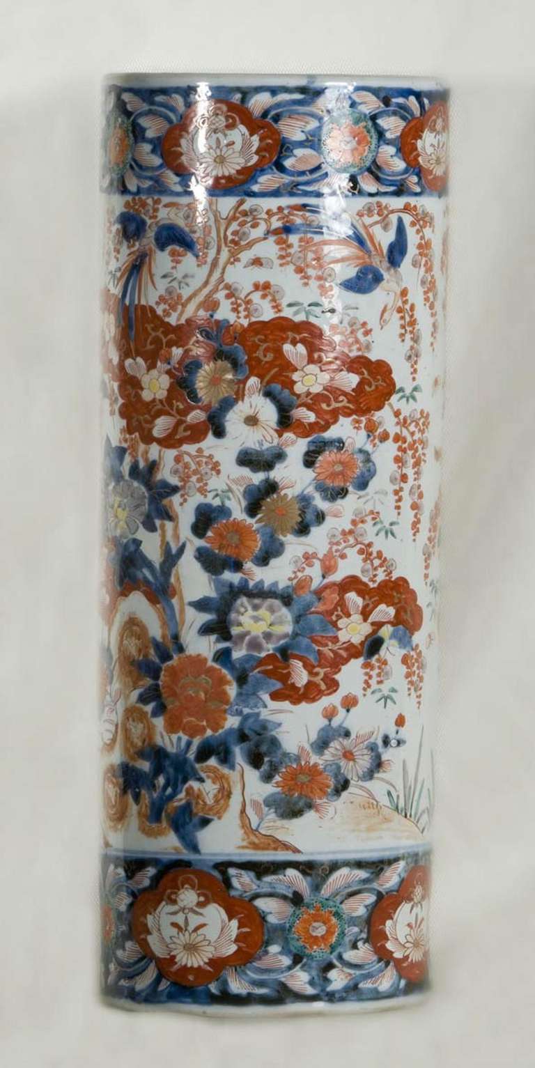 Handsomely decorated Imari umbrella stand.  Hand thrown porcelain and hand decorated in underglaze blue, iron red and turquoise touches.  Two large floral motifs painted on each side.  Decorative bands of color finish the design at the top and bottom