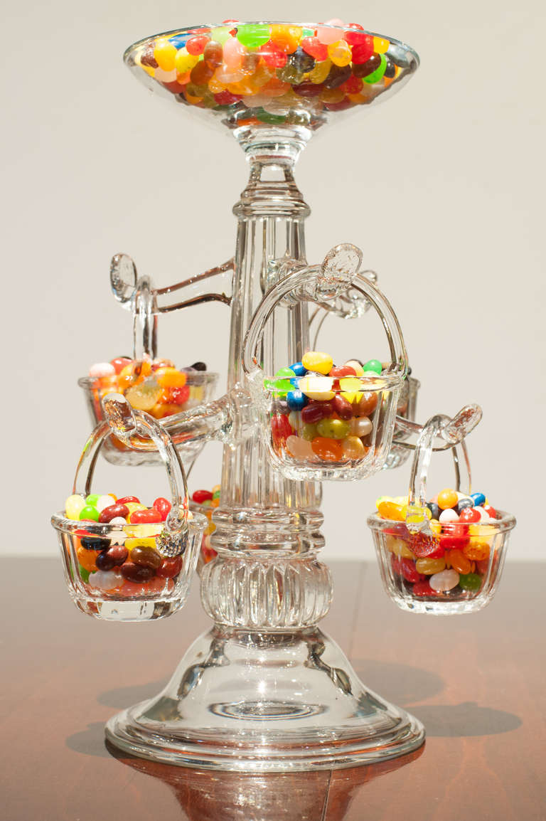 American three mold glass epergne from the French word for saving.  It was used as a centerpiece to hold any type of food or dessert.  The six removeable baskets have ground bottoms and applied handles [see thumbnail].  The glass has a remarkable