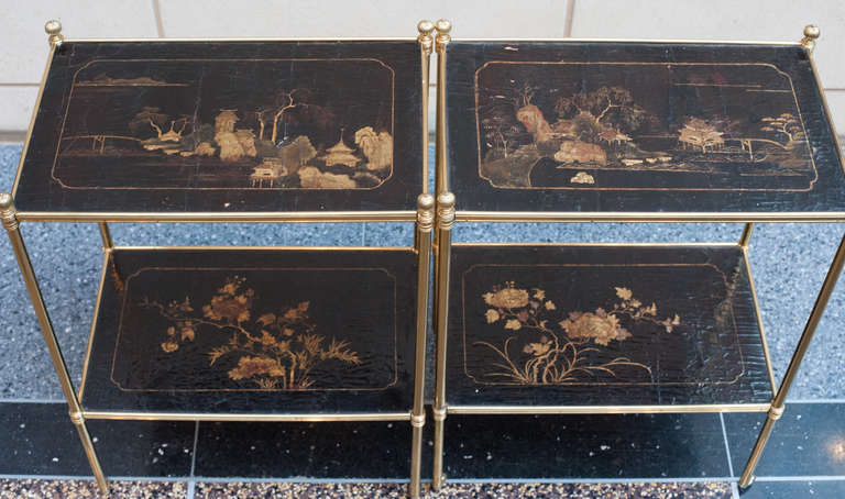 Pair of brass side tables on casters. They are set with two pair of matched Chinese, 18th century black lacquer panels. They have the round fluted finials that are the signature of Mallett of London. The tables came with plexi glass panels cut to