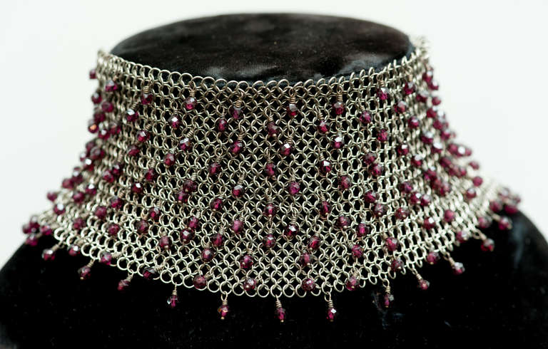 Sterling silver mesh choker attributed to Whiting and Davis with applied faceted garnets.  The choker is approximately 11