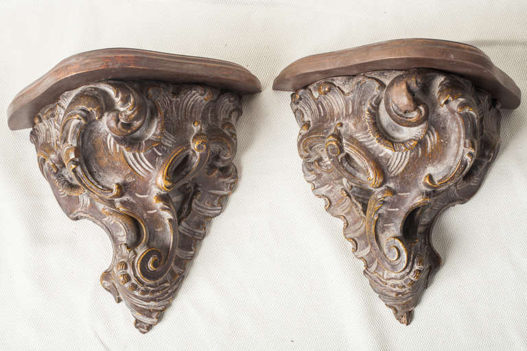 Pair of mirror image carved wood wall brackets with 