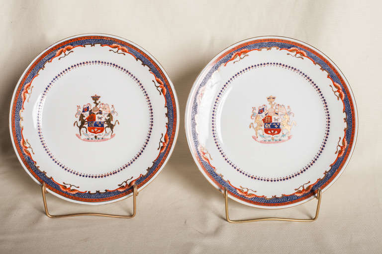Pair of armorial porcelain plates hand decorated in an iron red,  grey and blue and gold on a white ground. Marked on the back 