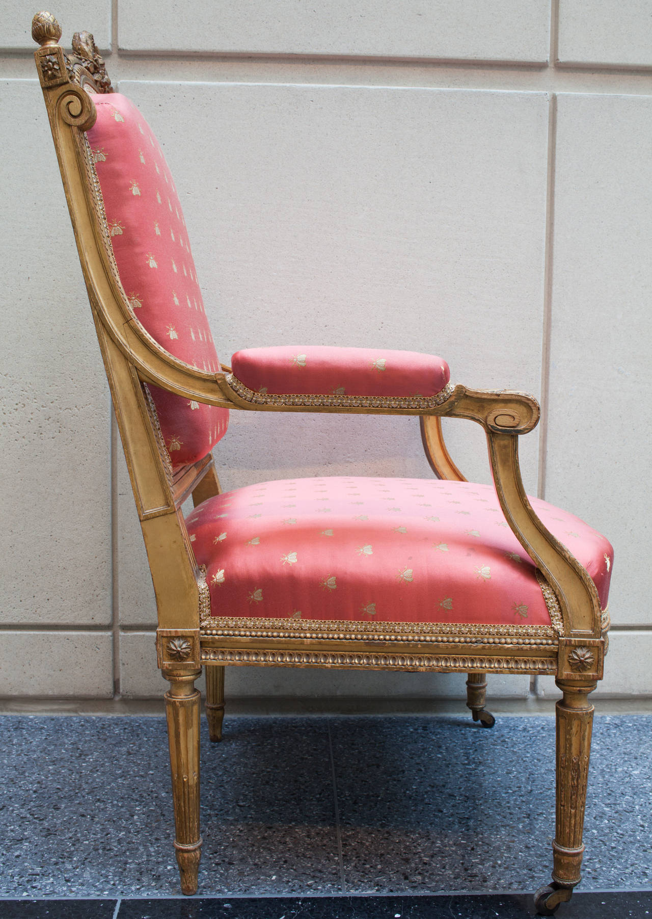This pair of bois doré period Napoleon III fauteuils are in the style of Louis XVI. The gilt finish is in Fine shape and the carved elements all refer to neo-classicism. The crest rail is topped by a laurel wreath. The hand rests and knees are