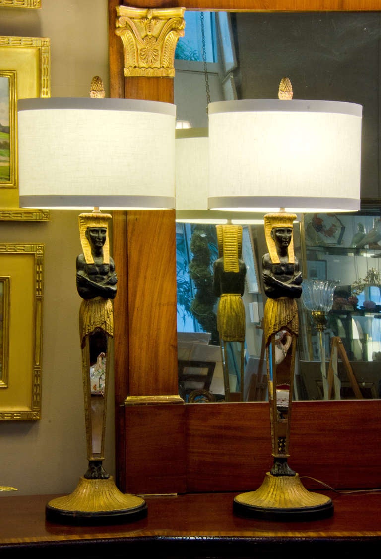 Pair of striking Egyptian revival lamps with mirrored supports and original gilt finials.  Pair of linen shades included.