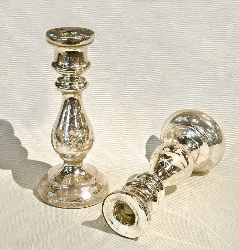 Pair of mercury glass candlesticks with hand painted leaf patterns in white.