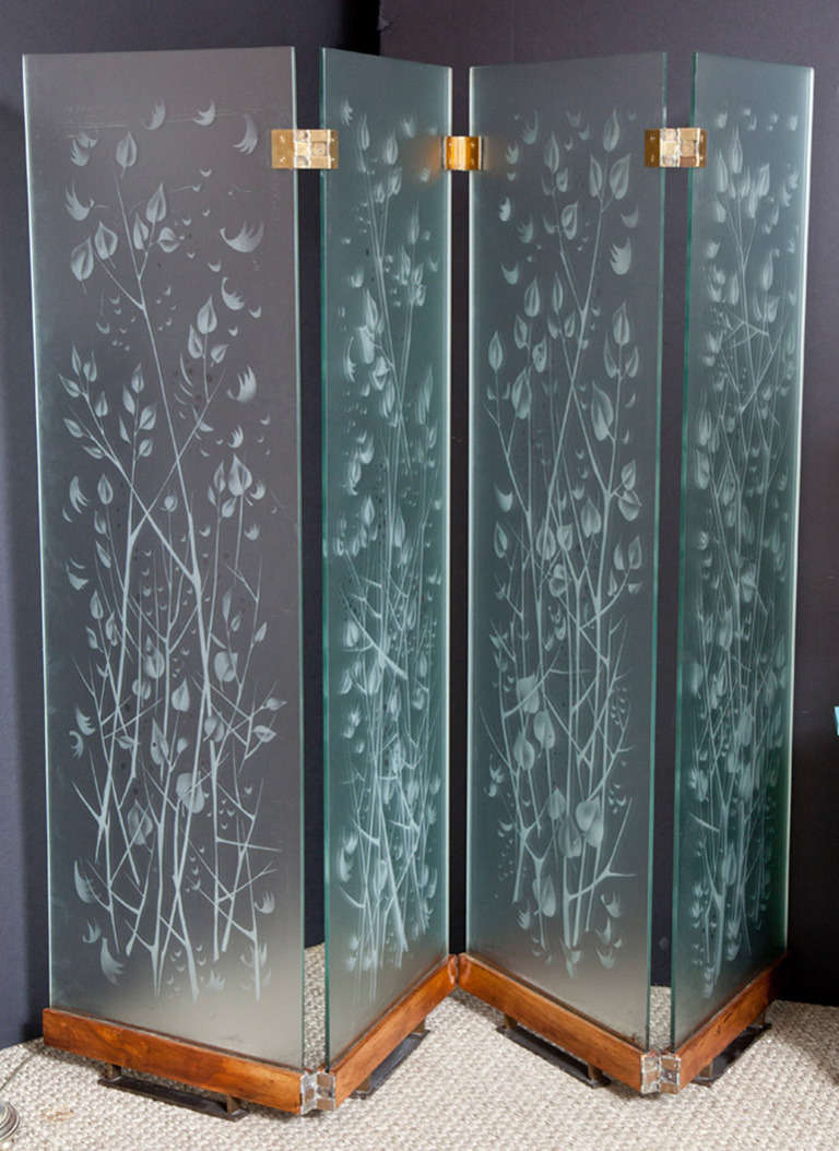 This spectacular glass screen or room divider came from a private home in the south of France. The four panels are housed in a stained oak base and are joined by handsome brass hinges. The beautiful etched design of branches and leaves give the