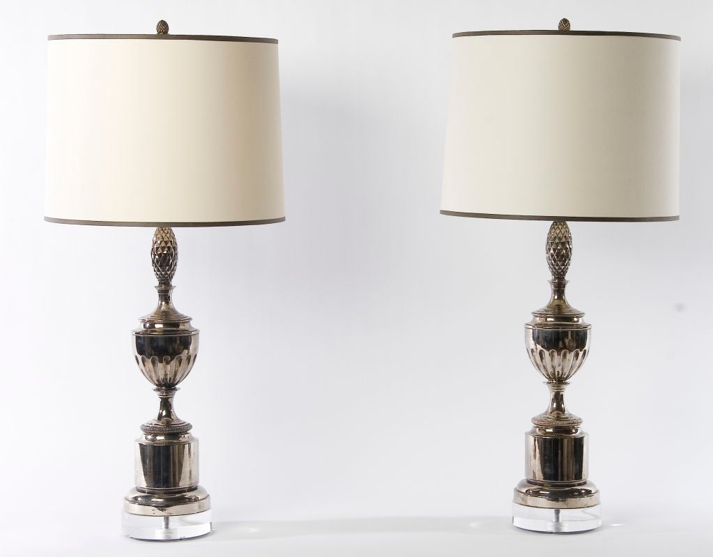 SOLD AS PAIR / $2,975 PAIR<br />
+ Modern take on a classical motif<br />
+ Stylized pineapples top traditional footed vases<br />
+ Newly nickel plated with 