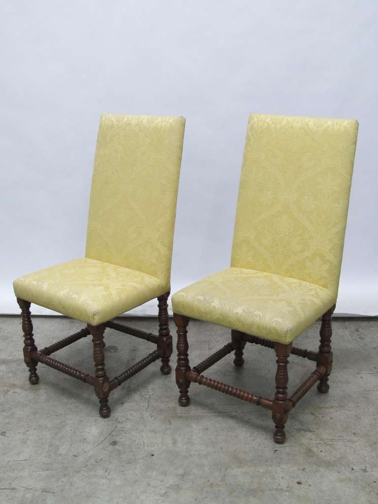 A pair of German Dining Chairs with walnut back and upholstery.
The back is veneered and cross banded.