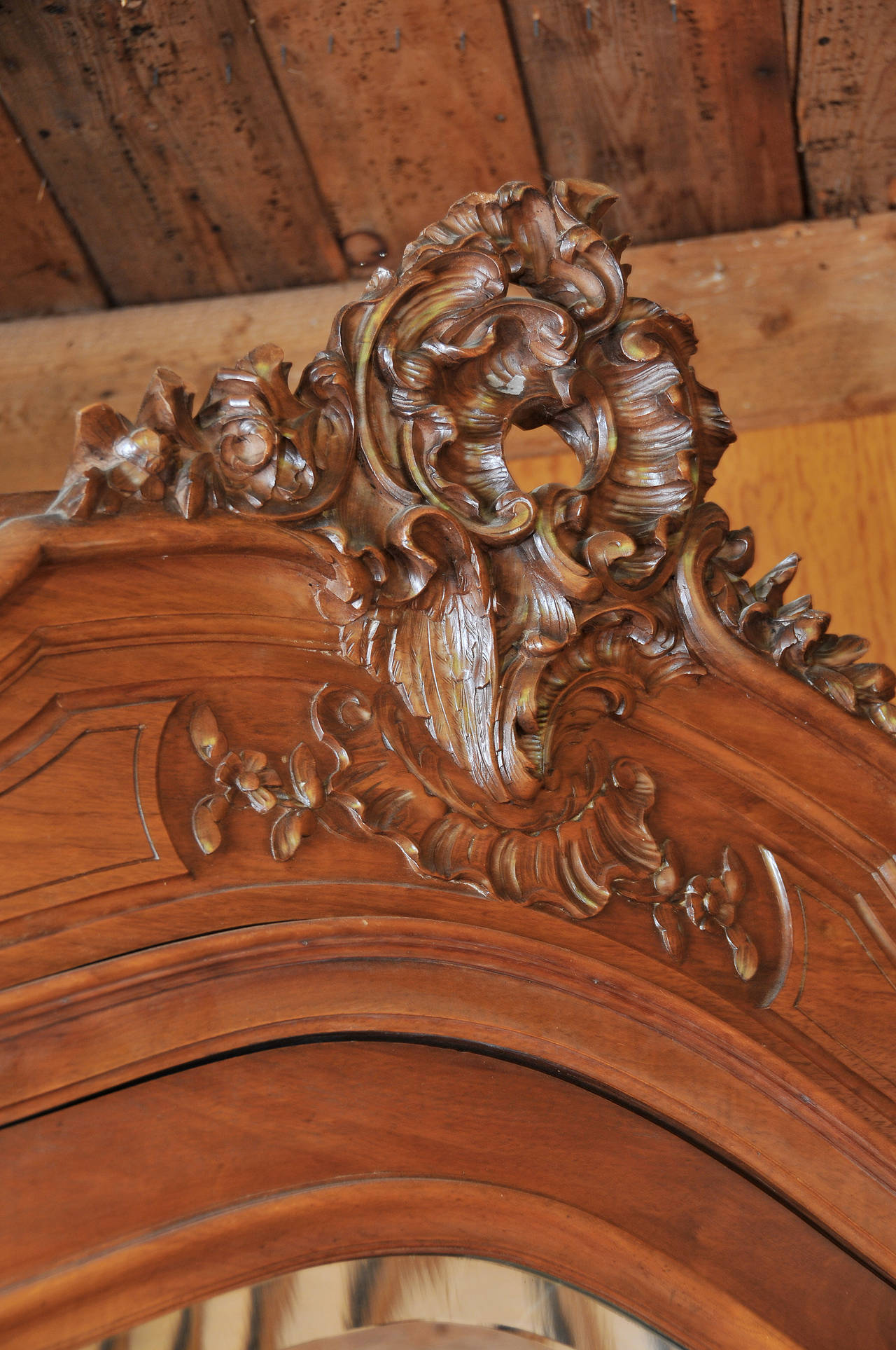 Large beveled mirror door 

Ornately carved crest 

Secret drawer  in base.