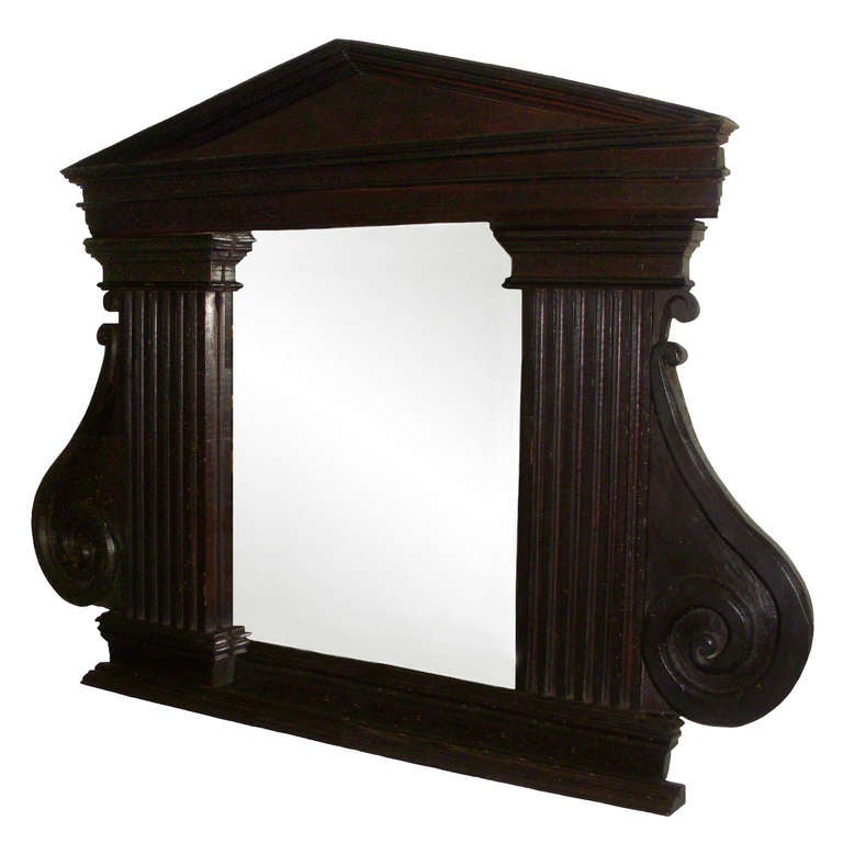 18th century, Louis XIV style ebonized mirror; with classical fluted columns; projected moldings and pediment; coinciding with the elegance of the neoclassical movement. Mirror may have been added later. Works well as an over mantle or dressing room