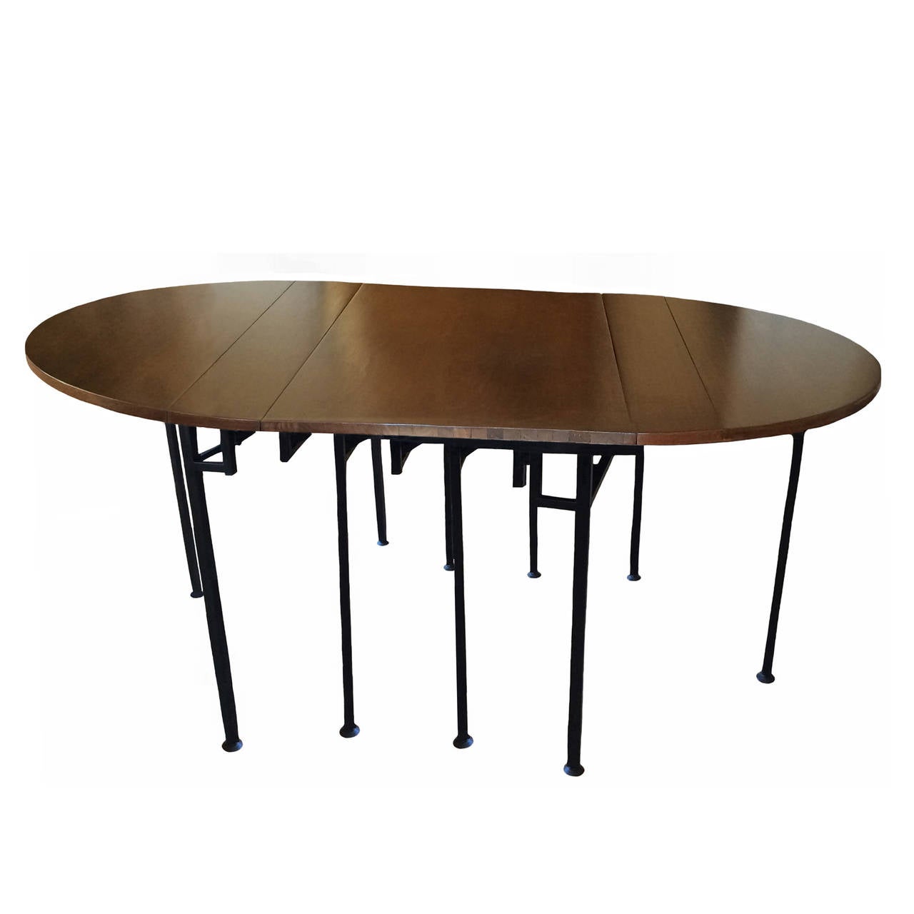A French mahogany oval extension table by Torrens et Fils in the style of Jansen with four leaves; black steel accordion base, stamped, circa 1950. The table measures 135.5 inches fully extended.
Each leaf is approximately 24 inches wide overall.