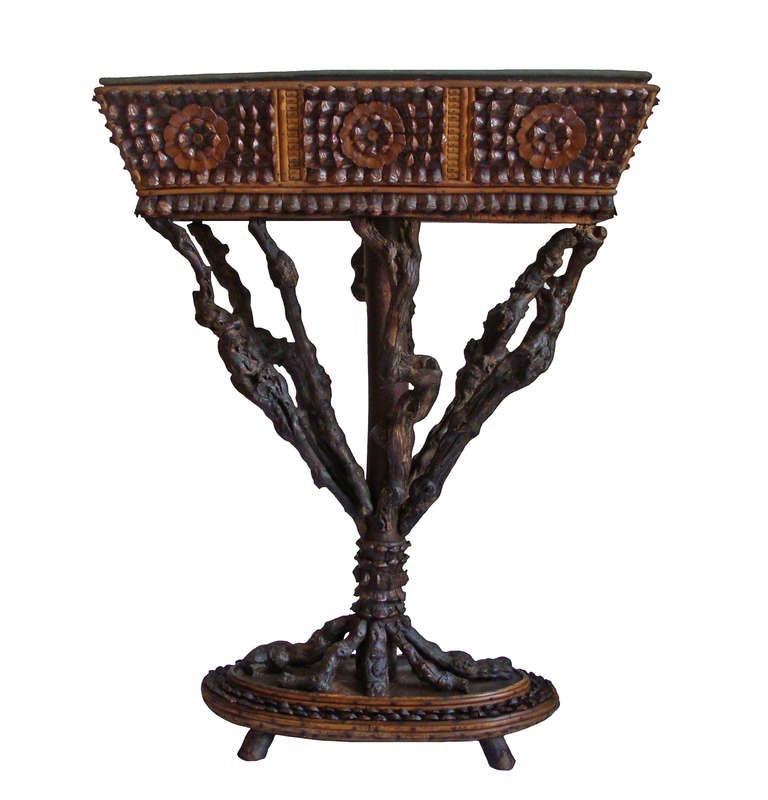A pair of intricately carved bois plant stands.  Elaborate pieces of wood forming a series of framed floral patterns.  Twisted, knarled tree trunk branches leading down to an oval platform with a beveled border on twig feet; zinc liners. 