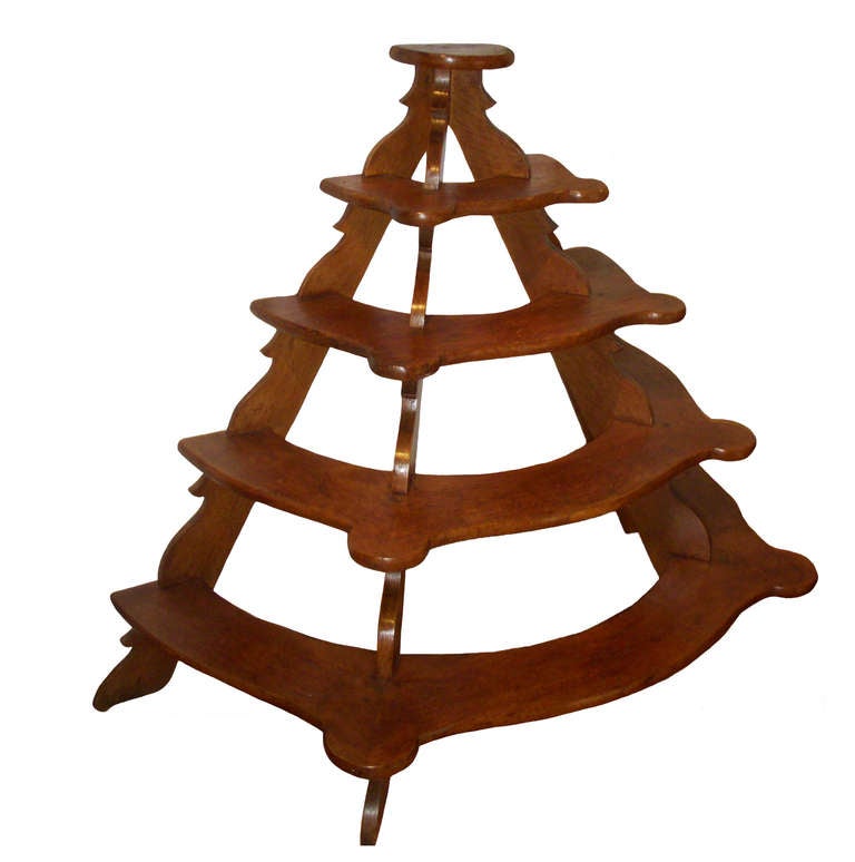 Artfully constructed French five-tier oak demilune plant stand; circa 1850.
Shaped shelves with rounded projections; scalloped carved tripod supports. Nice, rich patina.