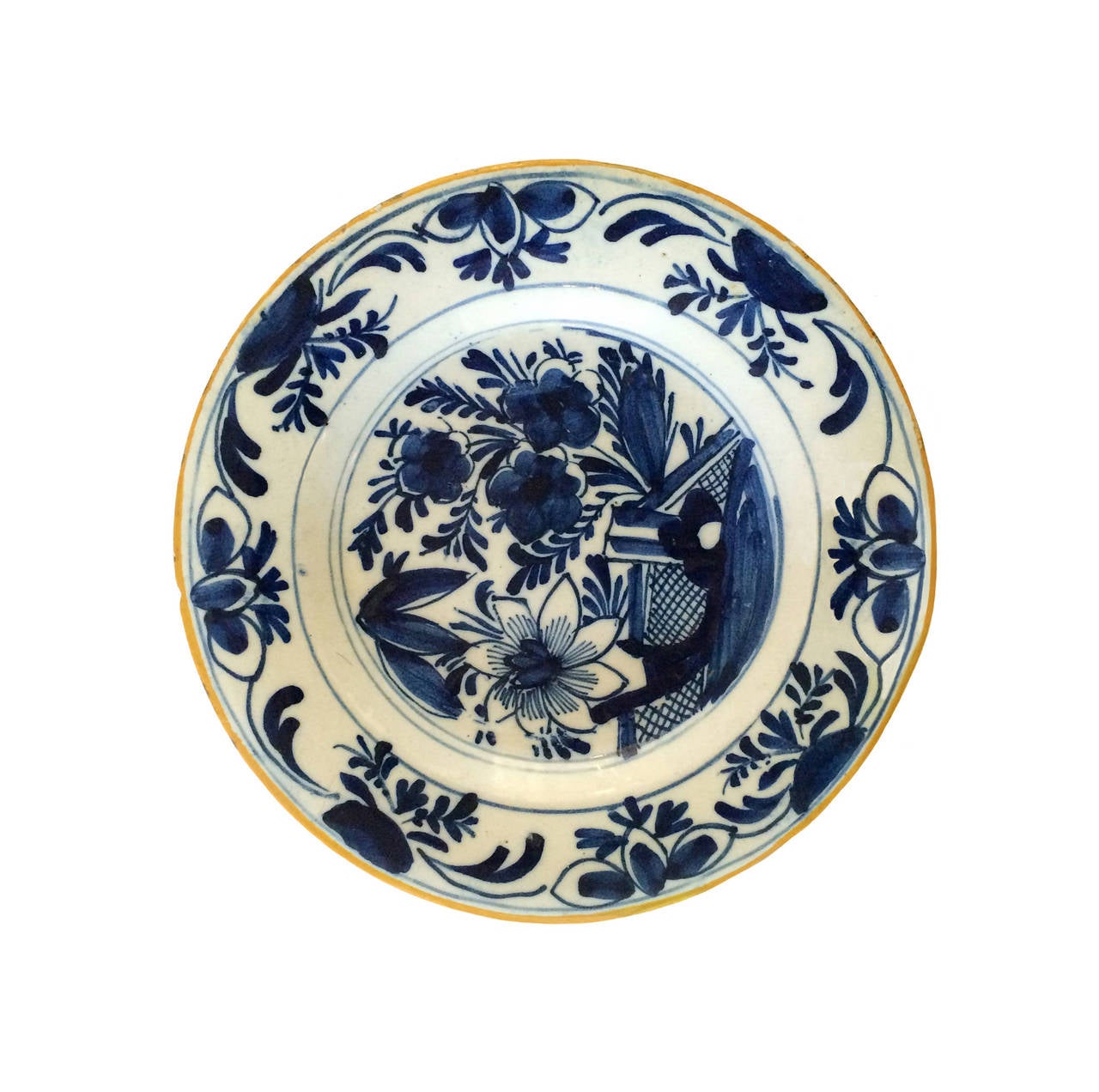 18th century blue and white Delft plate; floral center with a yellow border.
