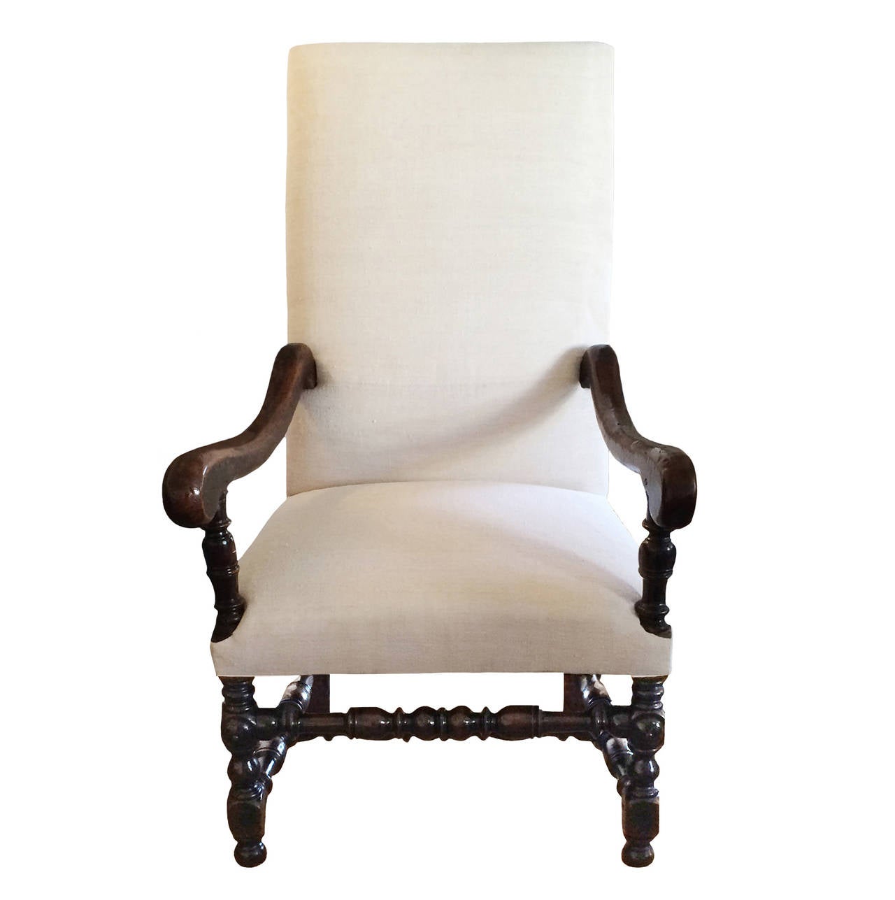 17th century Louis XIII walnut armchair; elongated curved arms; intricately shaped balustrade legs and stretcher; upholstered in vintage French linen.