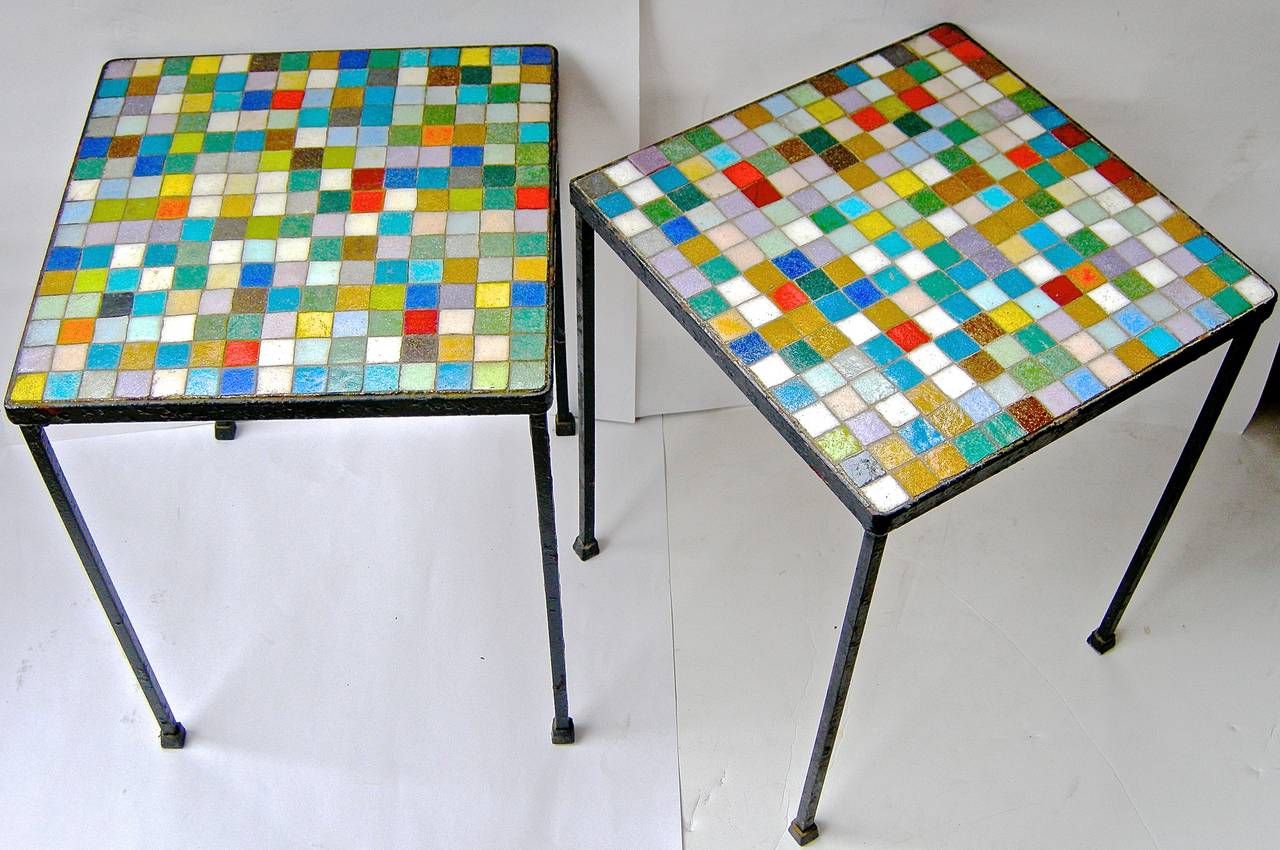 An eye catching pair of vintage, handcrafted, tile top side tables. Having extremely vivid and luminous grid-block tops of miniature colored tiles of myriad colors and hues. hand-wrought iron bases.

Height: 17